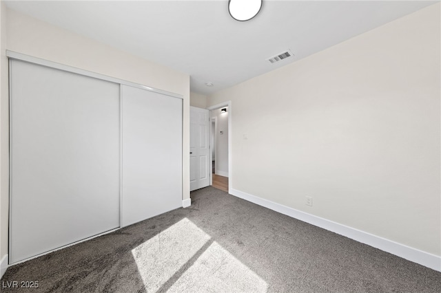 unfurnished bedroom with baseboards, a closet, visible vents, and carpet flooring