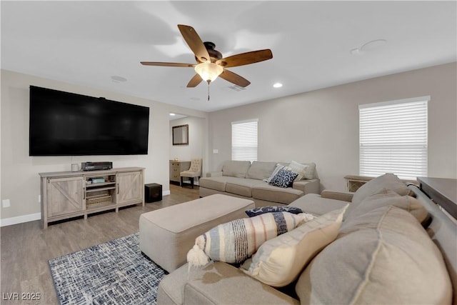 living area with light wood-style flooring, baseboards, a ceiling fan, and recessed lighting