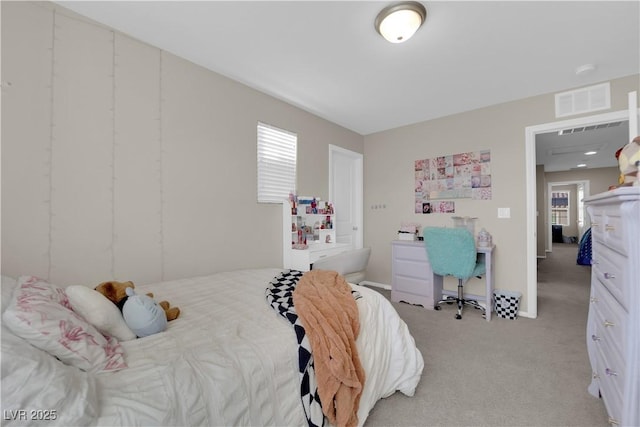 bedroom with visible vents and light carpet