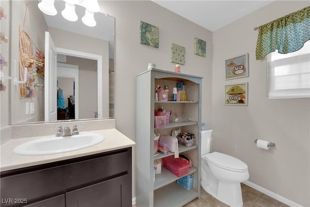 bathroom with toilet, tile patterned flooring, baseboards, and vanity