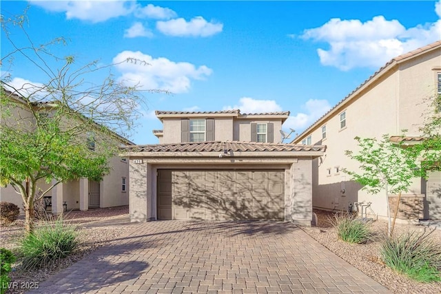 view of front facade with decorative driveway, a tiled roof, and stucco siding