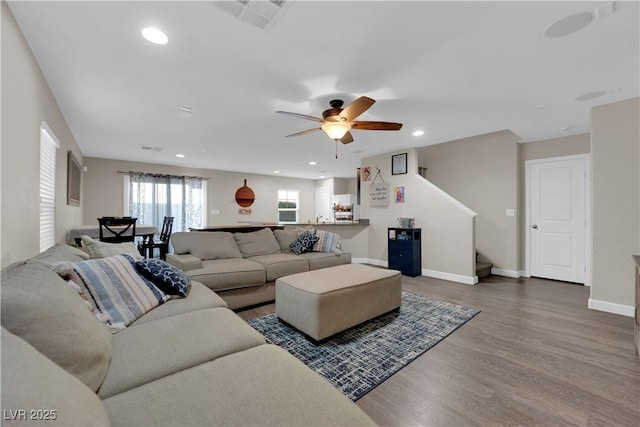 living area with baseboards, visible vents, stairway, wood finished floors, and recessed lighting