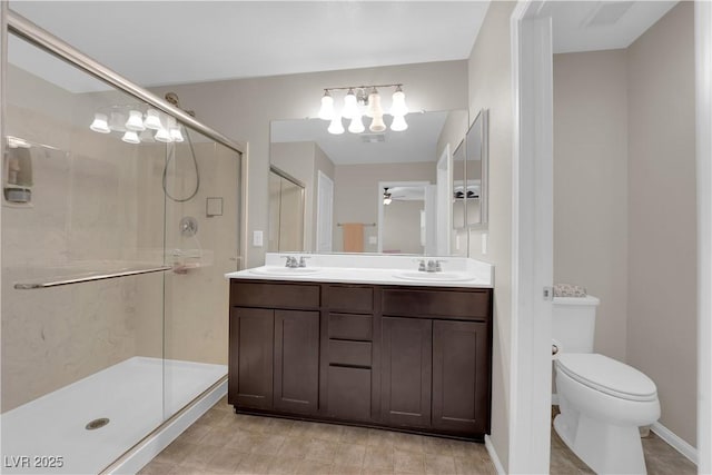 full bathroom featuring double vanity, a shower stall, toilet, and a sink