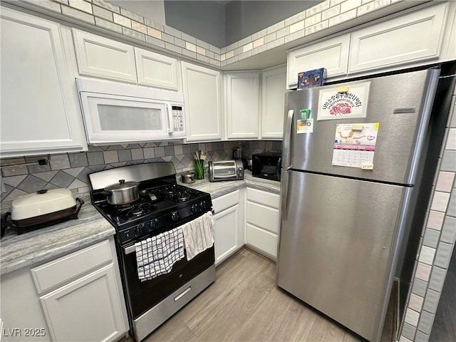 kitchen featuring white cabinets, black appliances, tasteful backsplash, and light countertops