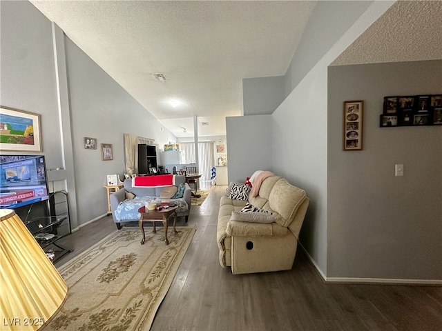 sitting room featuring lofted ceiling, a textured ceiling, visible vents, and wood finished floors