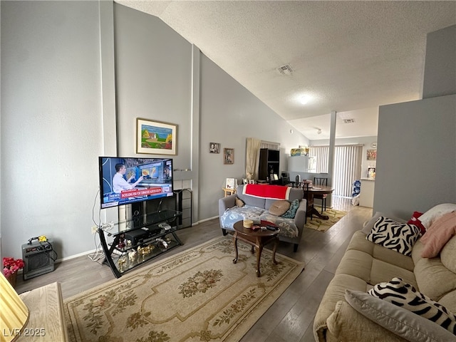 living room featuring visible vents, a textured ceiling, and wood finished floors