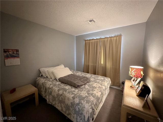 carpeted bedroom featuring visible vents and a textured ceiling