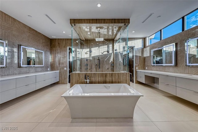 bathroom with a soaking tub, tile patterned flooring, vanity, a shower stall, and tile walls