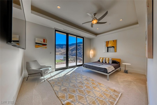 bedroom with access to exterior, a tray ceiling, carpet, recessed lighting, and baseboards