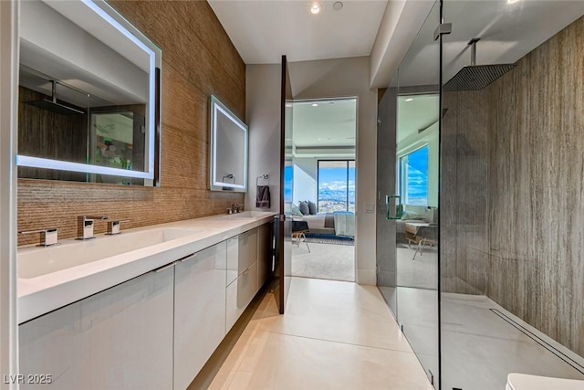 bathroom featuring connected bathroom, a sink, decorative backsplash, double vanity, and walk in shower