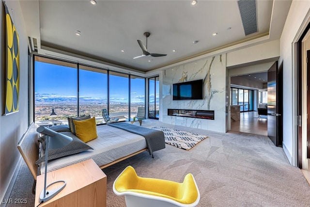 living area with recessed lighting, carpet floors, a ceiling fan, a high end fireplace, and floor to ceiling windows