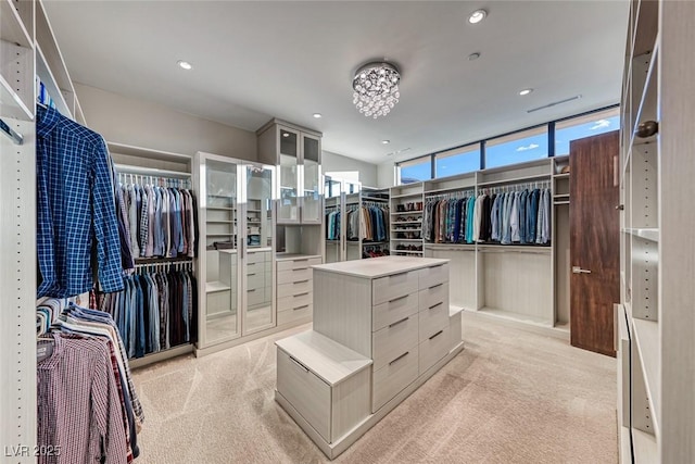 walk in closet with light carpet