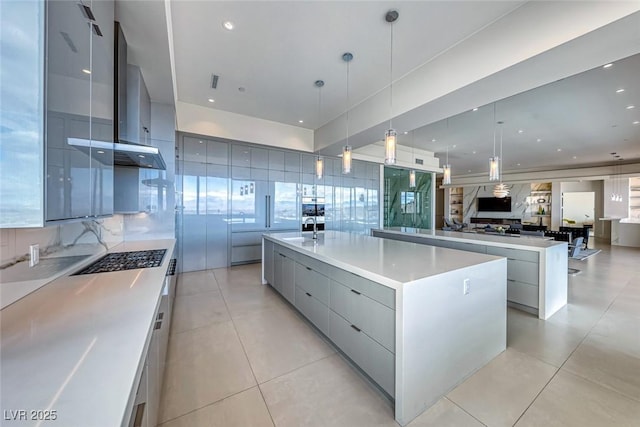 kitchen with a spacious island, tasteful backsplash, stainless steel gas cooktop, and modern cabinets