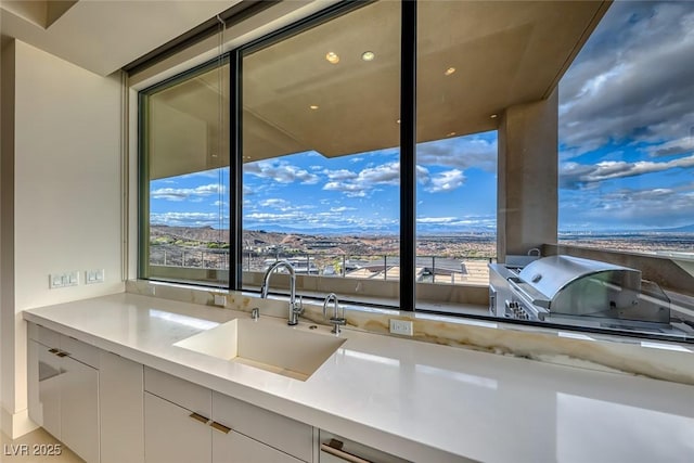 kitchen featuring light countertops, modern cabinets, a sink, and white cabinetry