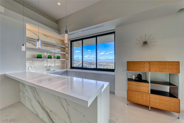 kitchen featuring light tile patterned floors, modern cabinets, a peninsula, light countertops, and pendant lighting