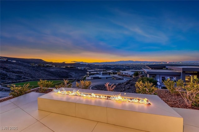 view of patio / terrace featuring an outdoor fire pit and a mountain view