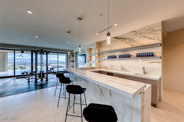 kitchen with recessed lighting, a sink, open floor plan, a kitchen bar, and decorative light fixtures