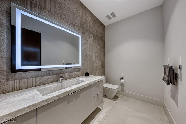 bathroom with visible vents, baseboards, toilet, tile patterned flooring, and vanity