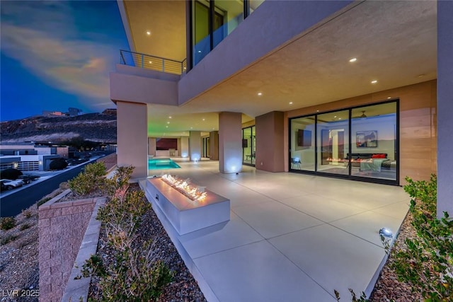 view of patio with a balcony and an outdoor pool