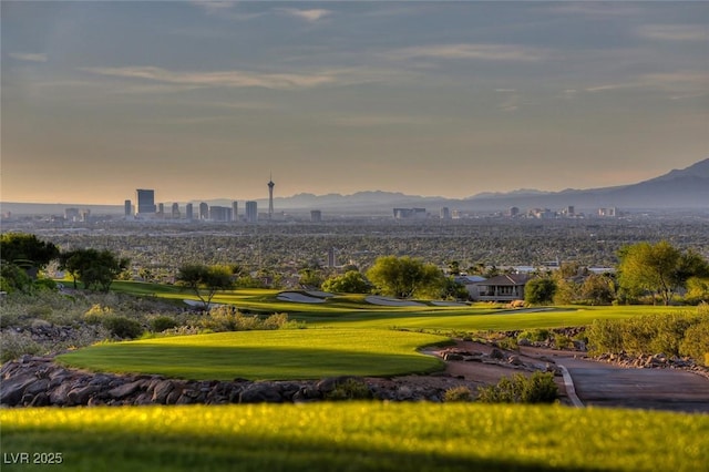 view of community featuring a view of city, a lawn, and a mountain view