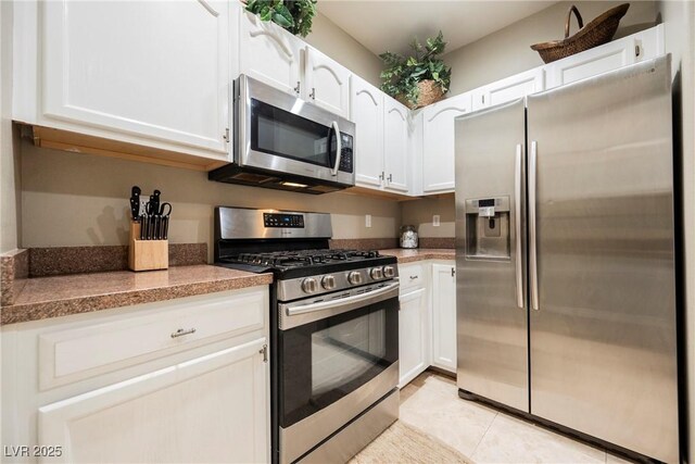 kitchen with white cabinetry, light tile patterned floors, and appliances with stainless steel finishes