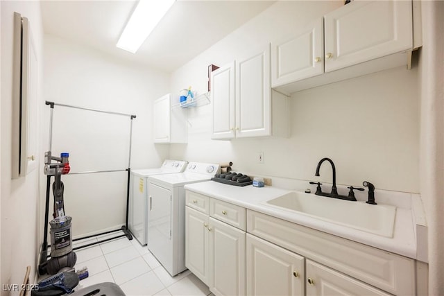 washroom with washing machine and clothes dryer, light tile patterned floors, cabinet space, and a sink