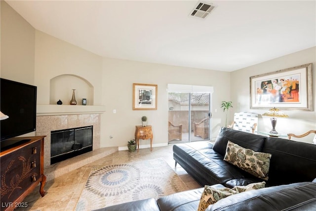 living room featuring a fireplace, visible vents, and baseboards