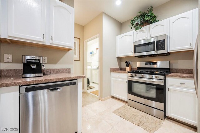 kitchen with light tile patterned floors, stainless steel appliances, baseboards, and white cabinets