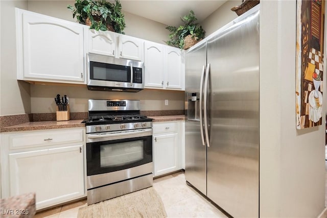 kitchen featuring light tile patterned floors, white cabinets, and appliances with stainless steel finishes