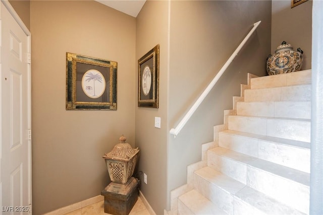 staircase featuring tile patterned floors and baseboards