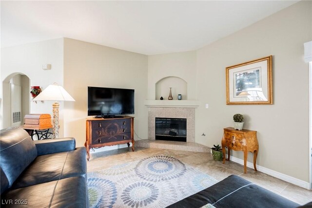 living area with baseboards and a tiled fireplace