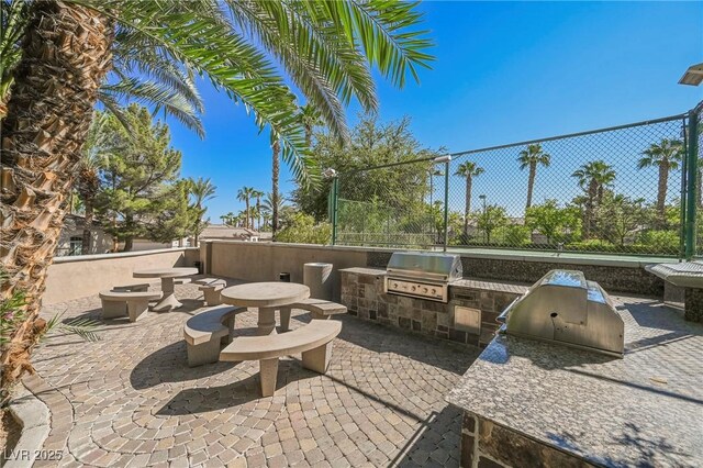 view of patio / terrace with area for grilling and fence