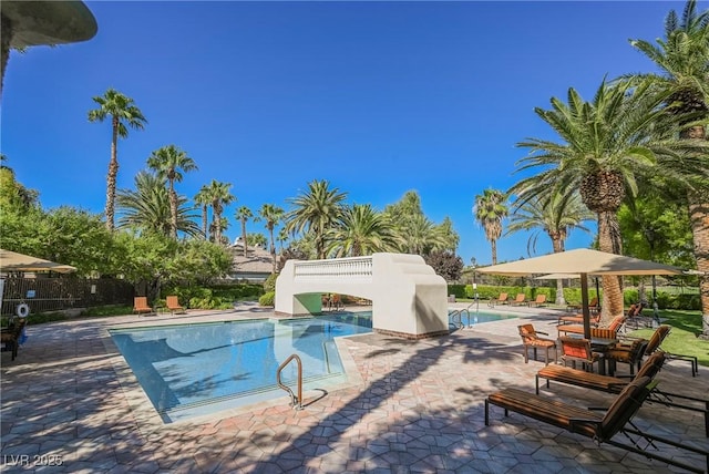 pool with a patio area and fence