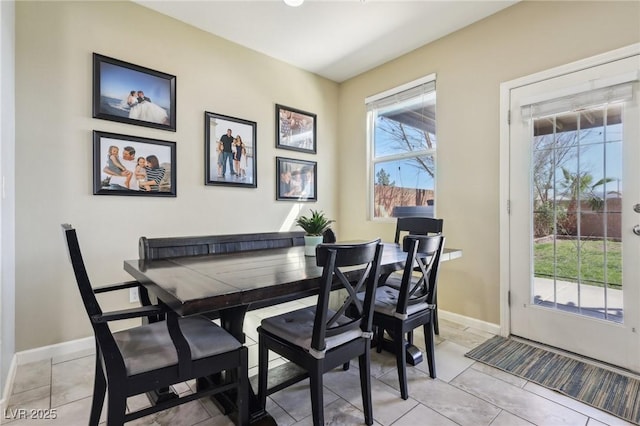 dining space featuring light tile patterned floors and baseboards