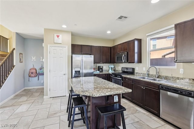 kitchen with a breakfast bar area, a sink, visible vents, appliances with stainless steel finishes, and a center island