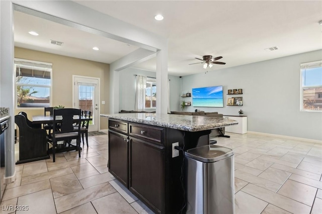 kitchen with baseboards, recessed lighting, visible vents, and light stone countertops