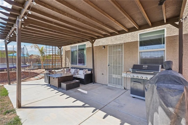 view of patio / terrace with a trampoline, area for grilling, fence, and an outdoor living space