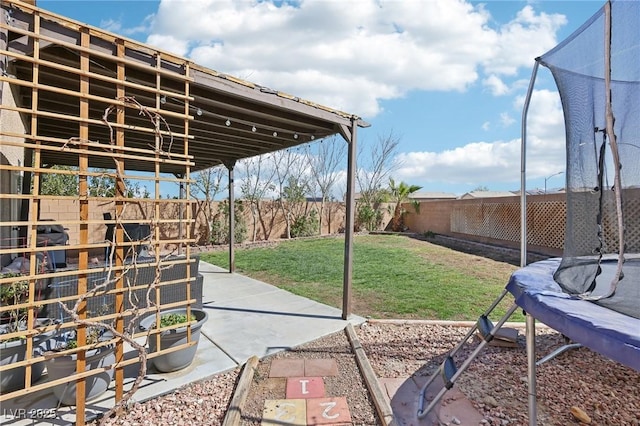 view of patio / terrace with a trampoline and a fenced backyard