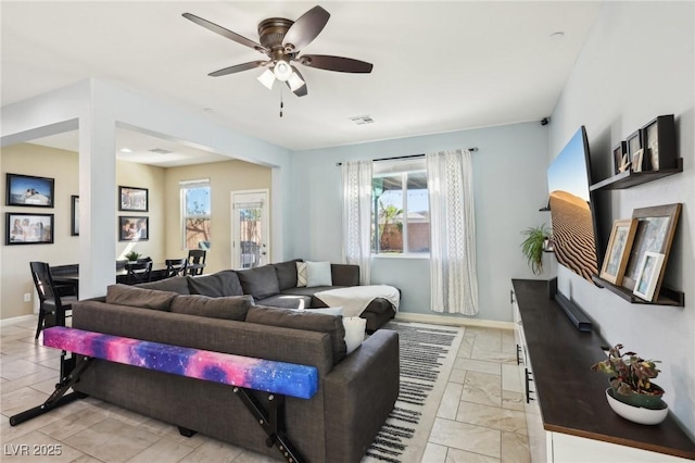 living room featuring a ceiling fan, visible vents, and baseboards