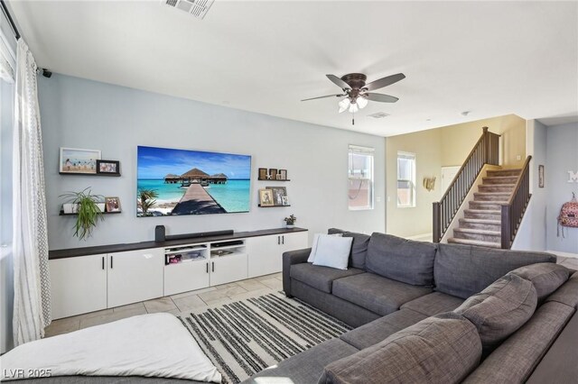 living area with visible vents, ceiling fan, and stairway