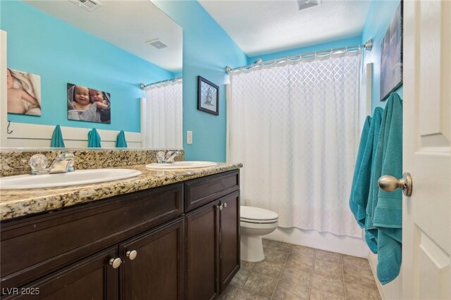 full bath featuring visible vents, a sink, toilet, and double vanity