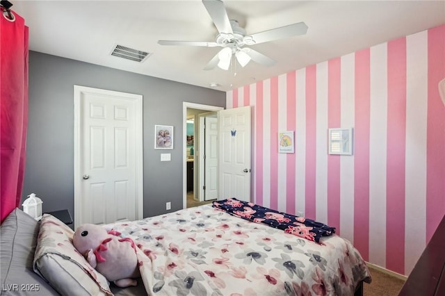 carpeted bedroom featuring wallpapered walls, ceiling fan, and visible vents