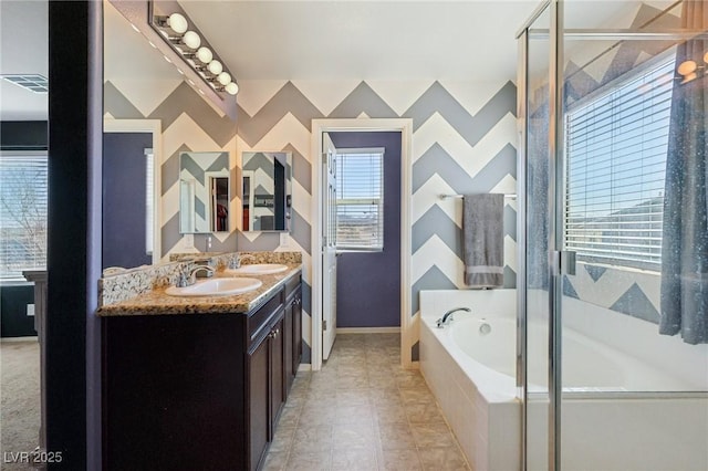 full bathroom with double vanity, a sink, a bath, and wallpapered walls