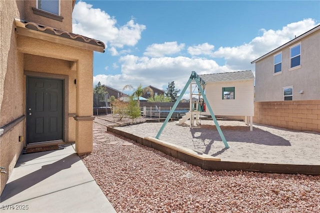 view of playground with a trampoline and fence