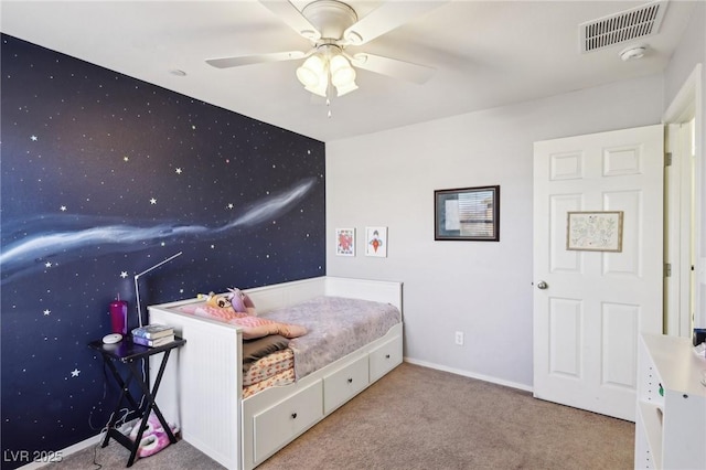 bedroom featuring carpet floors, an accent wall, visible vents, baseboards, and wallpapered walls