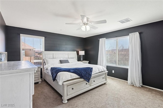 bedroom featuring baseboards, multiple windows, visible vents, and light colored carpet