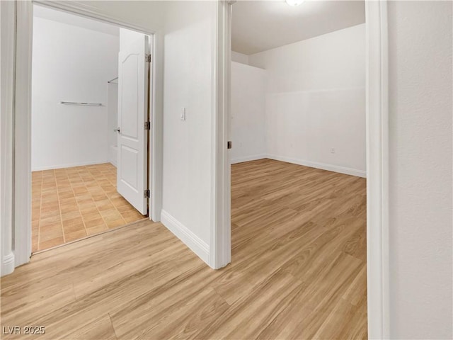 empty room with light wood-type flooring and baseboards