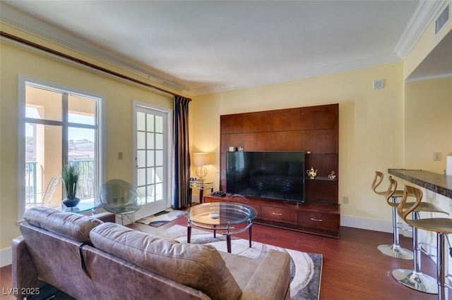 living area with dark wood-type flooring, visible vents, crown molding, and baseboards