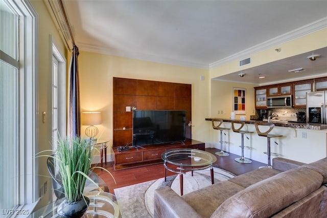 living area featuring visible vents, dark wood-type flooring, and crown molding