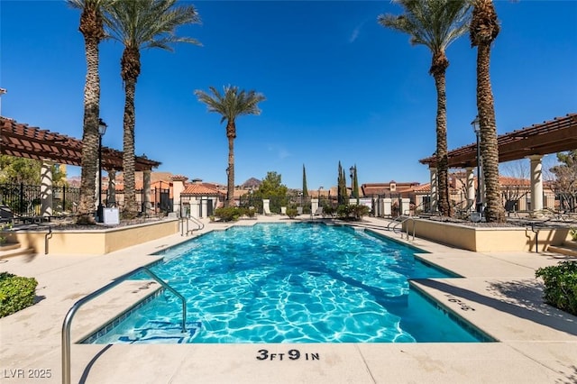 pool with a patio area, fence, and a pergola